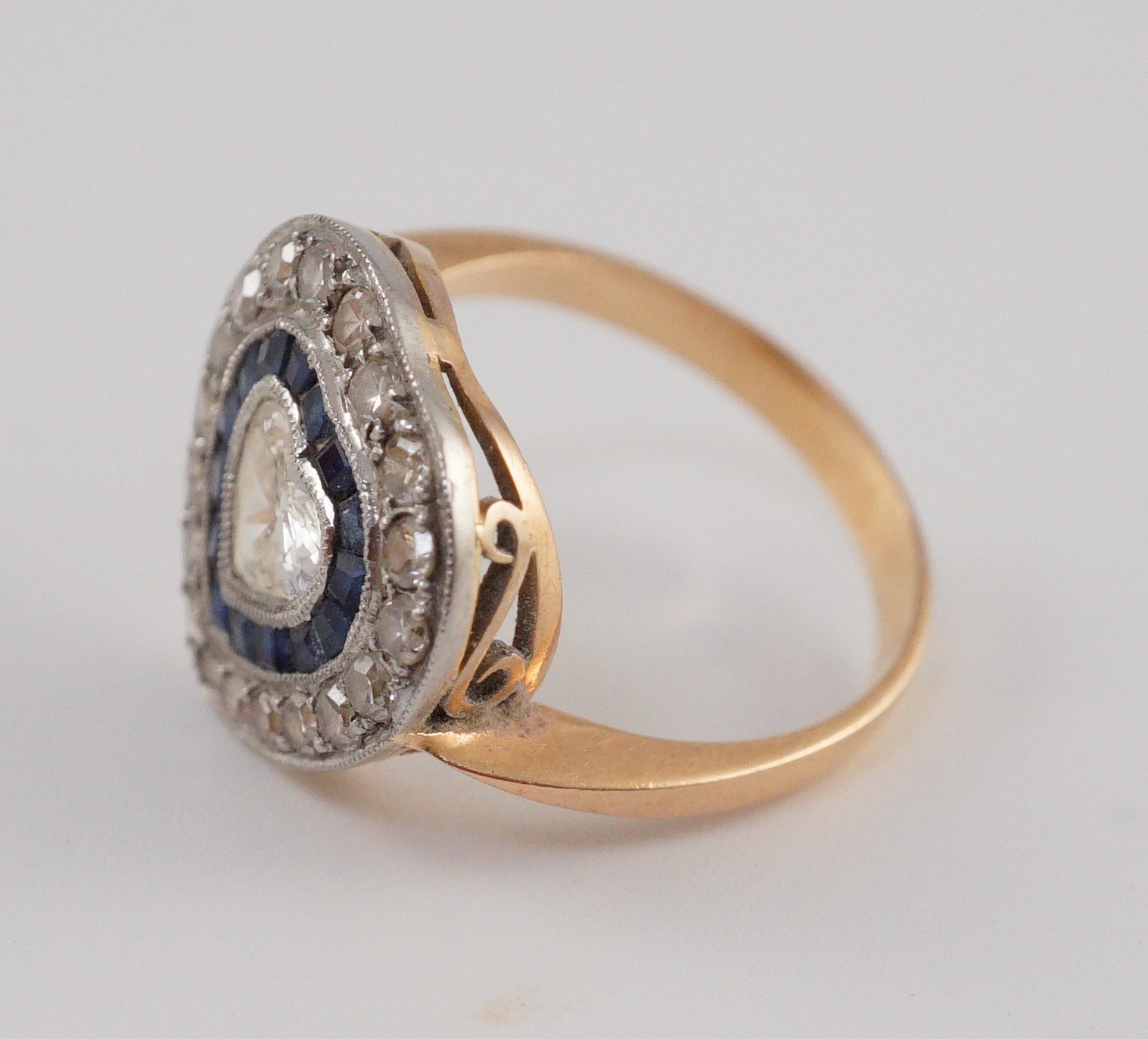 A 1920's, gold and platinum, millegrain set sapphire and diamond cluster set ring, with central heart shaped diamond